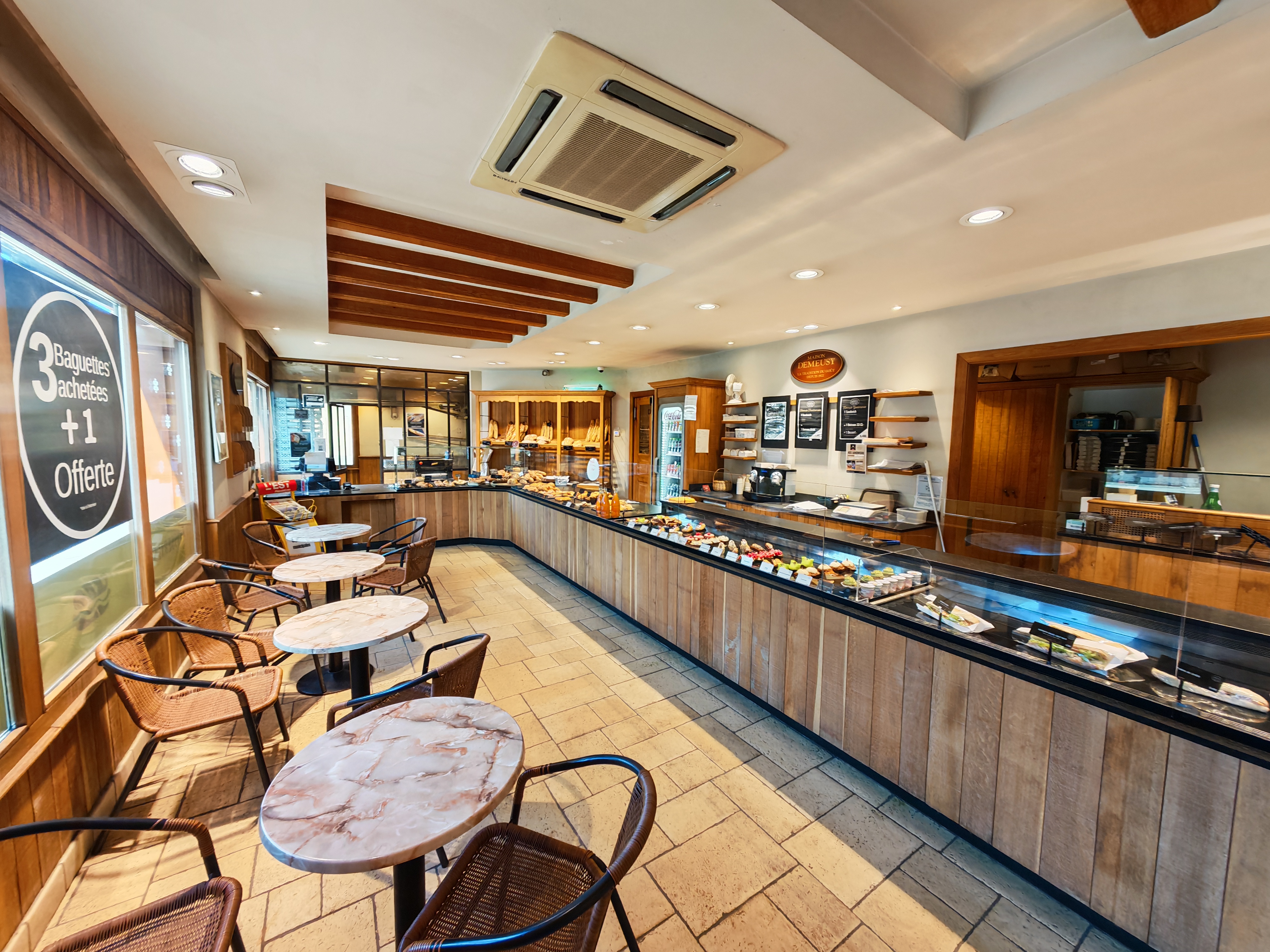 Salon de la boulangerie Maison Demeusy Bavilliers avec tables et chaises en rotin